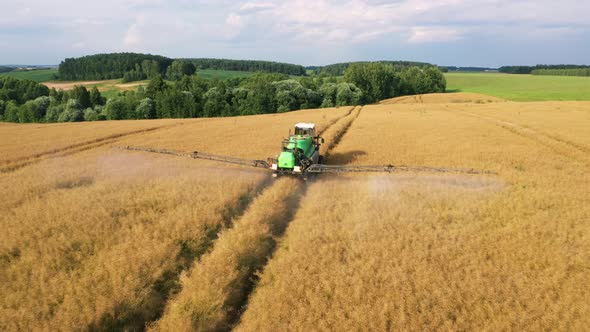 Aerial Agricultural Tractor Spraying On Cereal Field With Sprayer Fertilizer