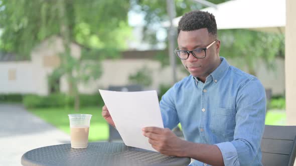 African Man Celebrating Success While Reading Documents