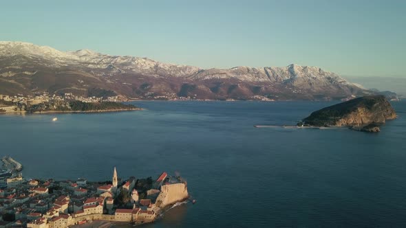 Aerial View of winter Budva, the old town in Montenegro and snow-capped mountains