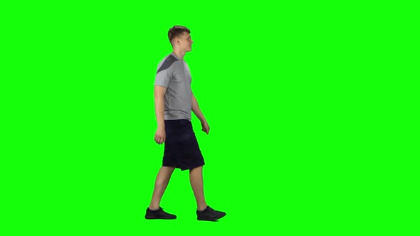 Young Man Walking on a Green Screen. Profile Side View