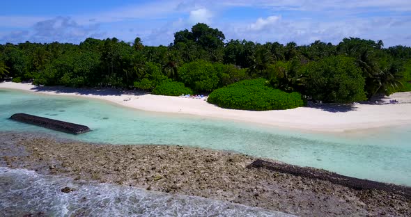 Tropical above travel shot of a white paradise beach and blue sea background in 4K