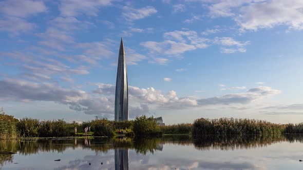 Clouds Moves Fast Above a Business Skyscraper Reflected in the Water Timelapse