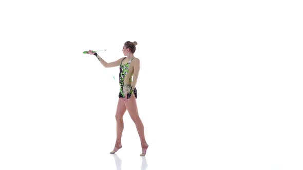 Girl Gymnast with Mace in Hand Revolve Around Him. White Background. Slow Motion