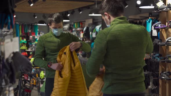 Man in Protective Mask Shopping Outdoor Equipment in Sports Store During Quarantine Covid 19