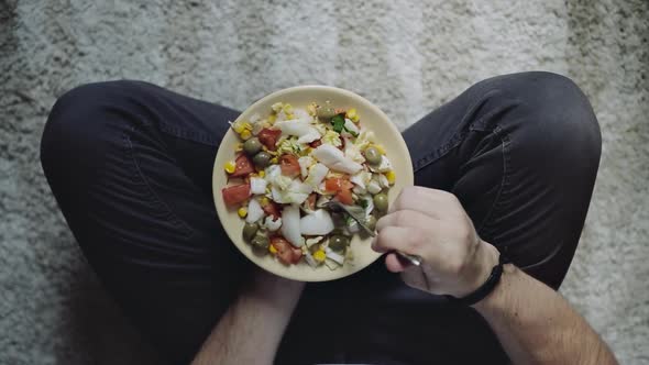 Man holding plate with salad, top view. Dieting, vegan food concept