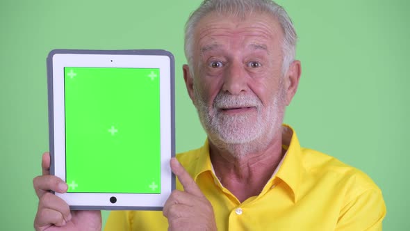 Face of Happy Senior Bearded Businessman Showing Digital Tablet