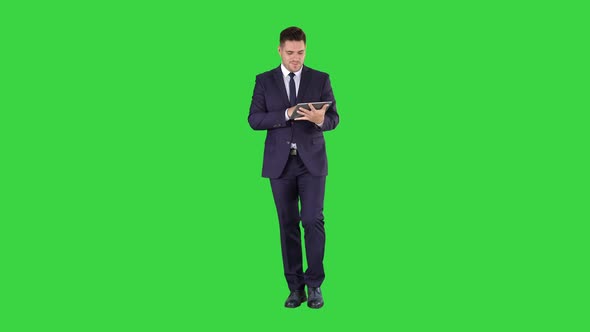 Businessman swiping pages on a tablet and talking to camera