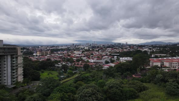Cinematic drone shot flying towards San Jose city, Costa Rica. Aerial cityscape