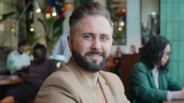 Portrait of Positive Caucasian Businessman in Cafe