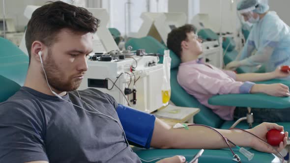 Blood Donor Listening to Music on Phone