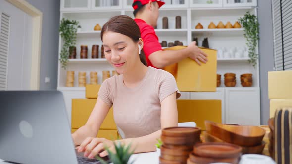 Asian young woman using call phone and laptop check order for customer.