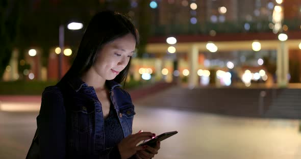 Woman use of mobile phone on earphone at night