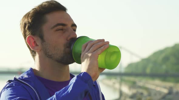 Shot of a Handsome Young Man Drinking Water After Working Out