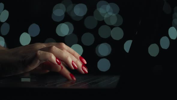 Female Hands is Typing on a Laptop at Night