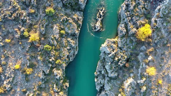 Narrow stream flowing through rocky desolate landscape. Aerial view of Cijevna river in Montenegro