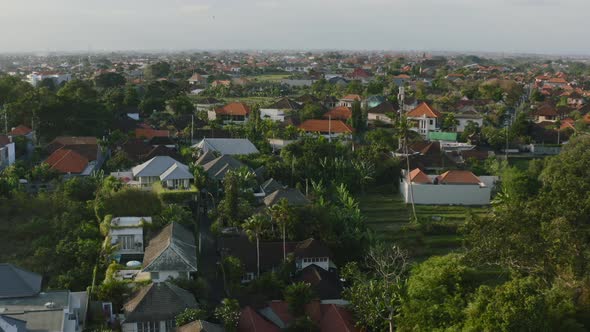 aerial of residential area during sunset in bali indonesia surrounded by rice fields
