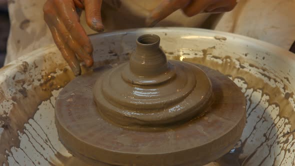 Potter making a earthen pot on a pottery wheel