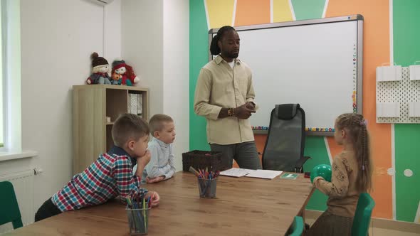 African American Teacher Teaches Children in the Classroom