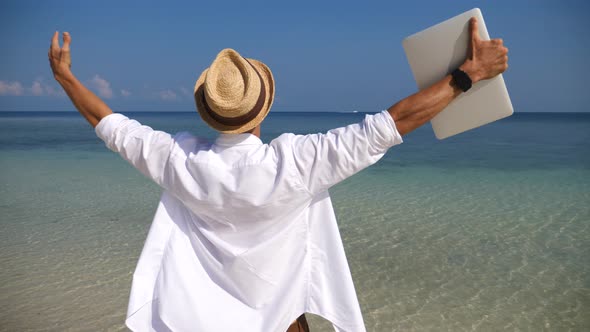Business Man With Arms Outstretched Holding Laptop Enjoying Beach Holidays