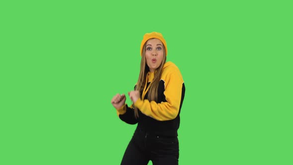 Modern Girl in Yellow Hat Is Dancing Funny. Green Screen