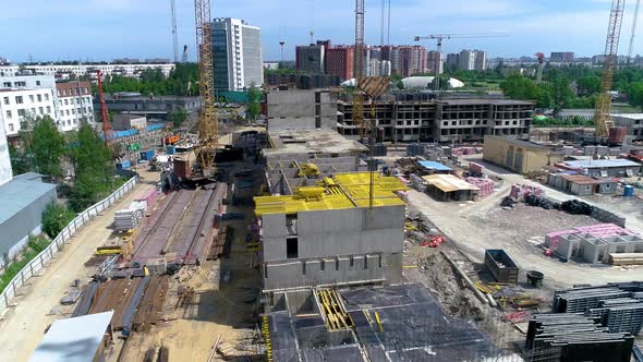 Bird's-eye view of a construction site. Yellow crane boom in the foreground