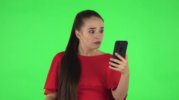 Portrait of Pretty Young Woman Is Angrily Talking for Video Chat Using Mobile Phone. Green Screen