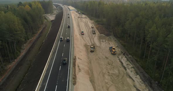 Aerial View of Road Construction Site and Cars and Trucks Driving on New Highway