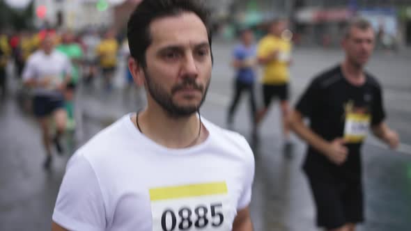 Marathon Athlete Running in Group of Other Sportsmen During Athletic Competition