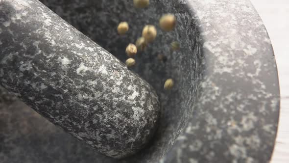 Super Close-up of Green Peppercorns Falling Into the Grey Stone Mortar