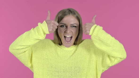 Excited Young Girl Showing Thumbs Up, Pink Background