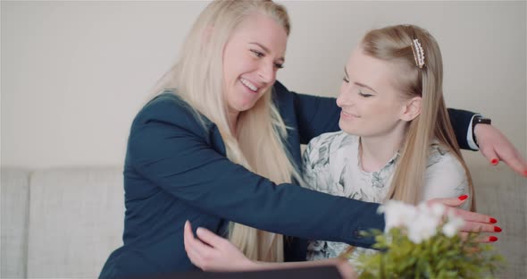 Two Happy Sisters Hugging Together and Giving Support To Each Other Smiling Into Camera