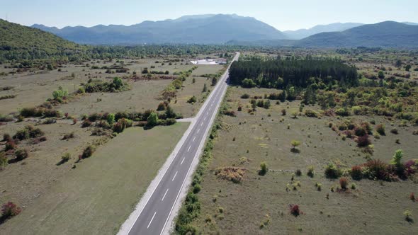 Aerial View Empty Asphalt Road on the Plateau Between Green Fields Highland Way