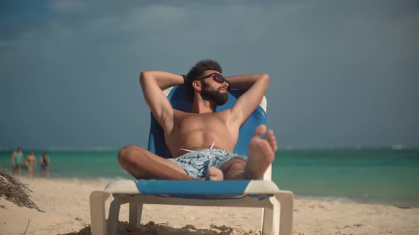 Man Lies On Sunbed On Vacation. Traveler Resting Beach Hotel Luxury. Guy Lying On Sun Lounger.