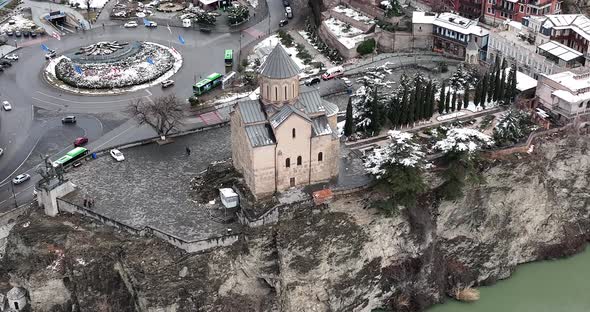 Aerial view of Metekhi church in old Tbilisi located on cliff near river Kura. Georgia 2022 winter