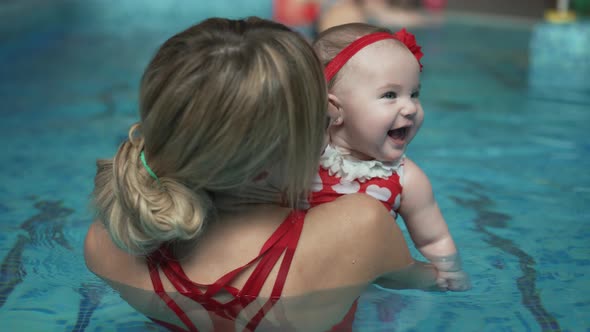 Happy Mother with a Baby in the Pool