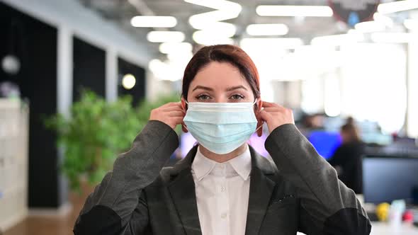 A Happy Female Office Worker in a Suit Takes Off Her Medical Mask and Breathes Freely with Full