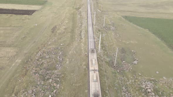 Flying over Georgian Railways train moving in beautiful alpine mountains