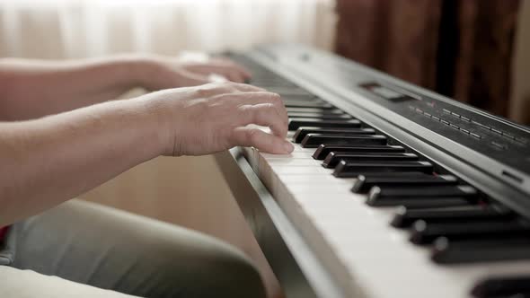 Close up of woman's hand playing the electric piano.