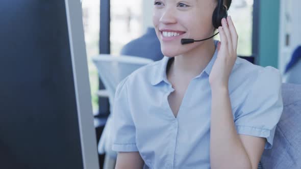 Young woman with headset working on computer