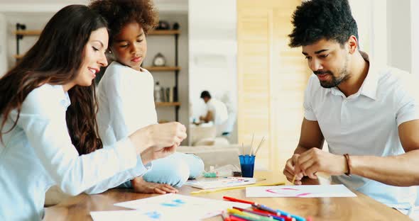 Mother and Father Drawing Together with Their Child