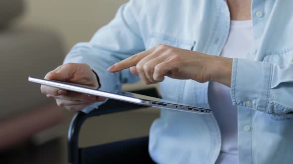 Woman Registering in Mobile App on Tablet, Online Queue to Rehabilitation Center