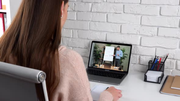 Businesswoman at Home Office Listen Online Video Call Laptop Writes in Notebook