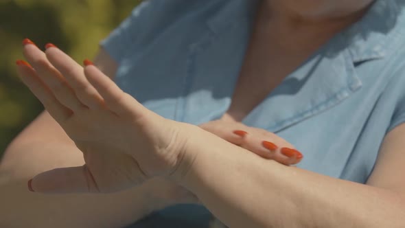 Unrecognizable Senior Woman Applying Sunscreen Outdoors. Female Caucasian Hands Rubbing Moisturizer