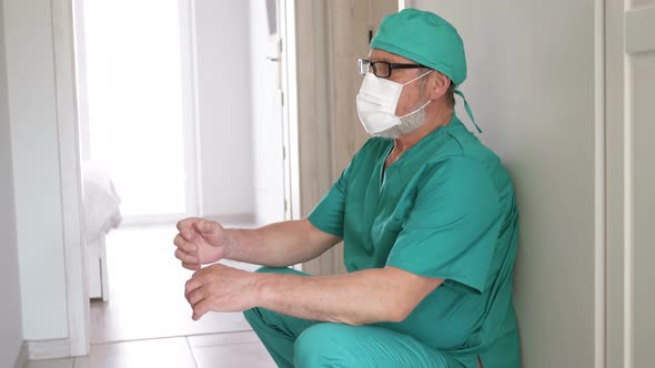 Tired Doctor Leaning Against Wall in Hospital.