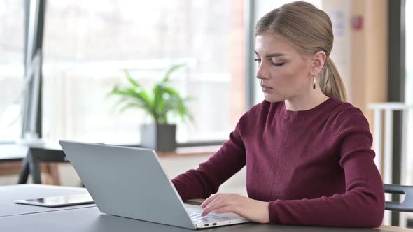 Professional Young Woman Using Laptop in Office