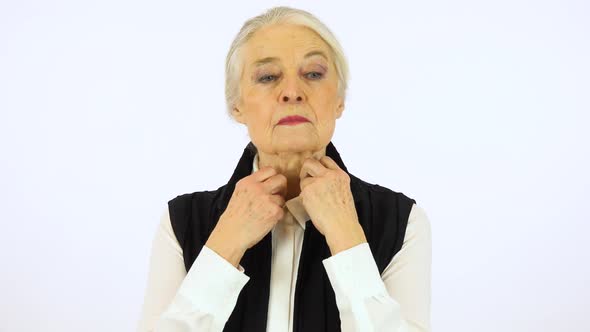 An Elderly Woman Adjusts Her Clothes and Smiles at The Camera - White Screen Studio