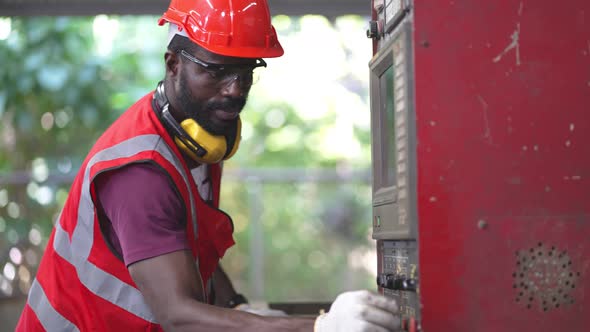 Factory worker operating control big machine in the industrial construction.