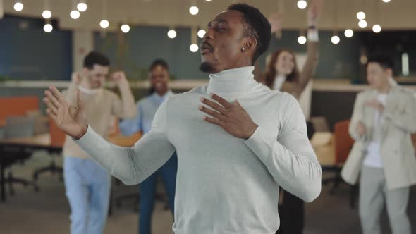 Man Dancing at Corporate Party in Office with Colleagues