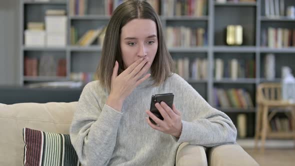 Portrait of Young Woman Reacting To Loss on Smartphone