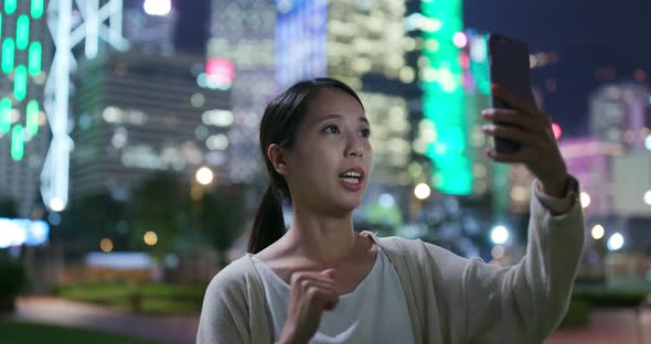 Woman use of mobile phone for making live stream at outdoor in the evening